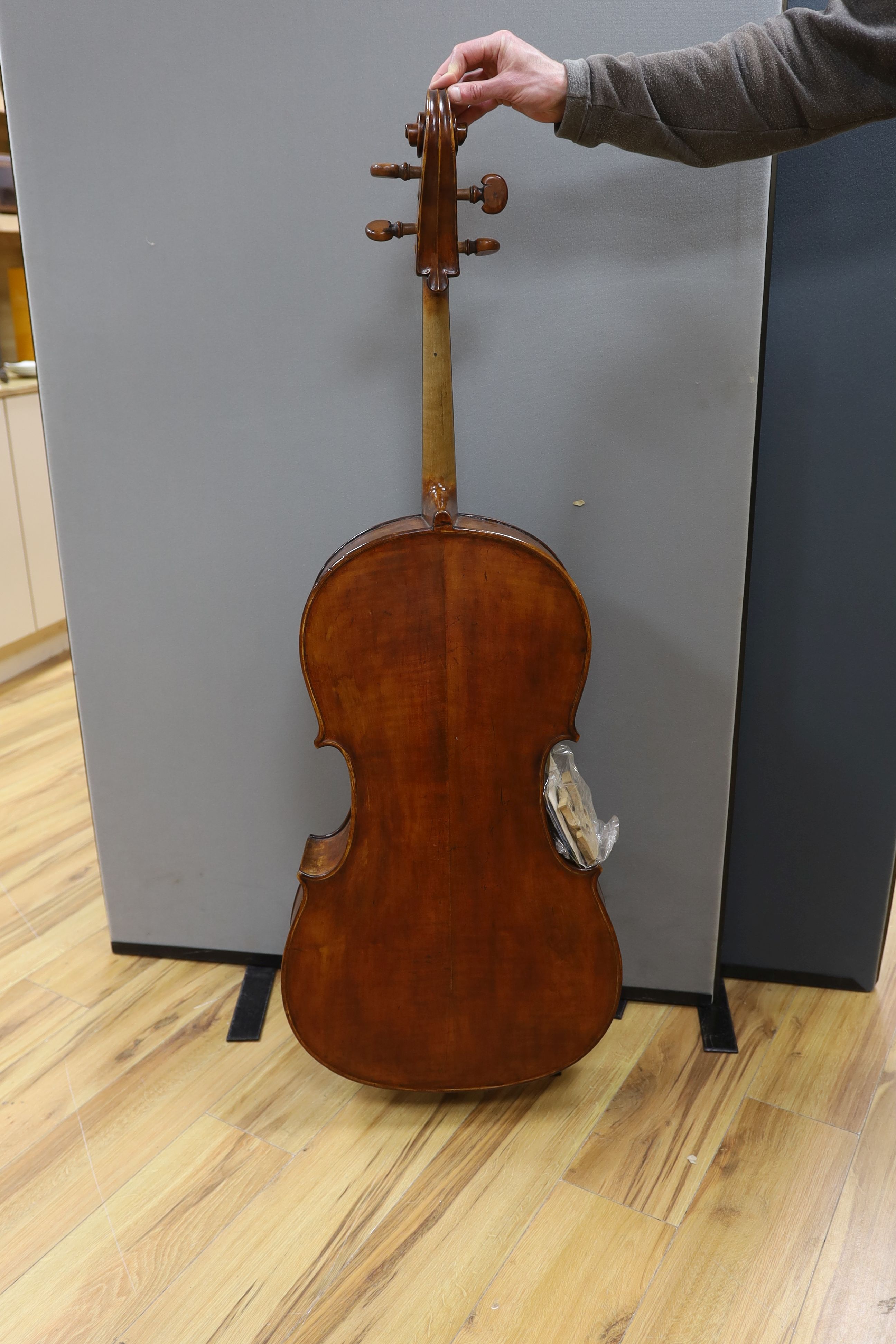 A cased early 20th century ‘cello, length of body 75.5cm, with two spare bridges, and spare strings